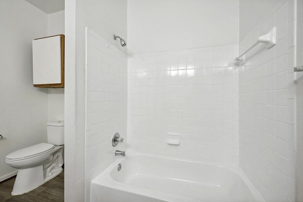 Bathroom with white tile at Fountains at Tidwell and The Enclave in Houston TX
